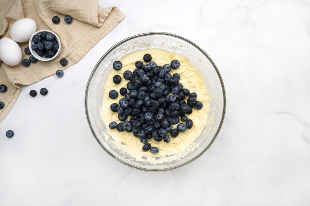 Adding blueberries to batter for easy blueberry muffin recipes.