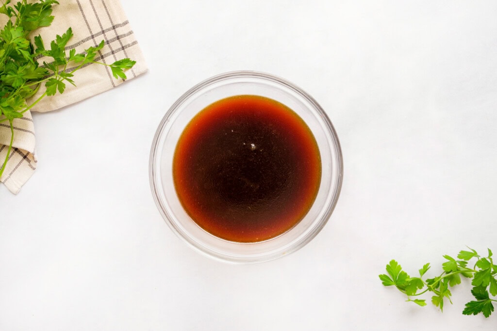 Beef broth and soy sauce in bowl.