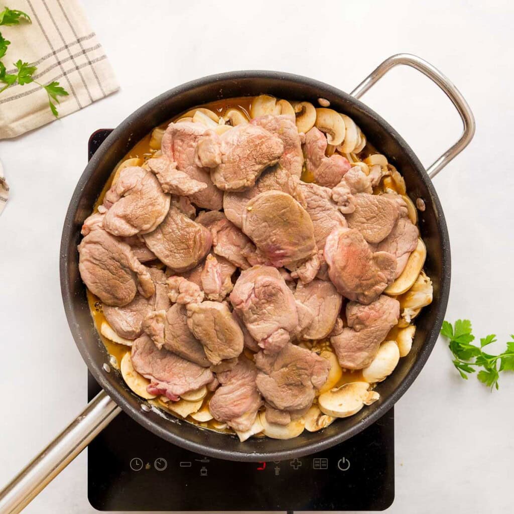 Adding pork tenderloin medallions back to skillet.