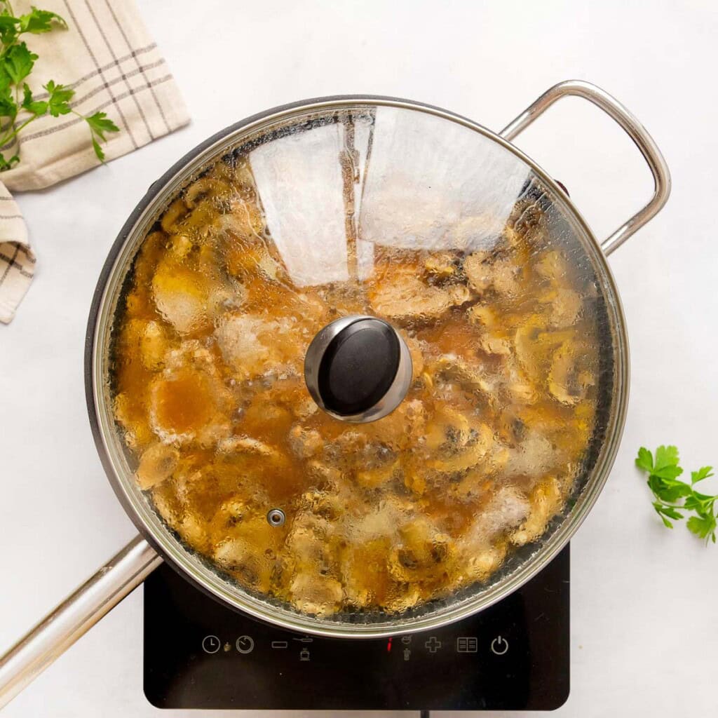 Pork Tenderloin Medallions with mushrooms cooking in skillet.