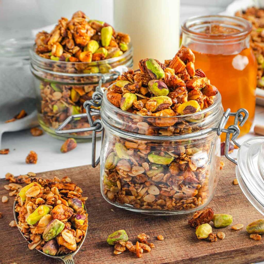 High Protein Granola recipe in glass jars with serving spoon.