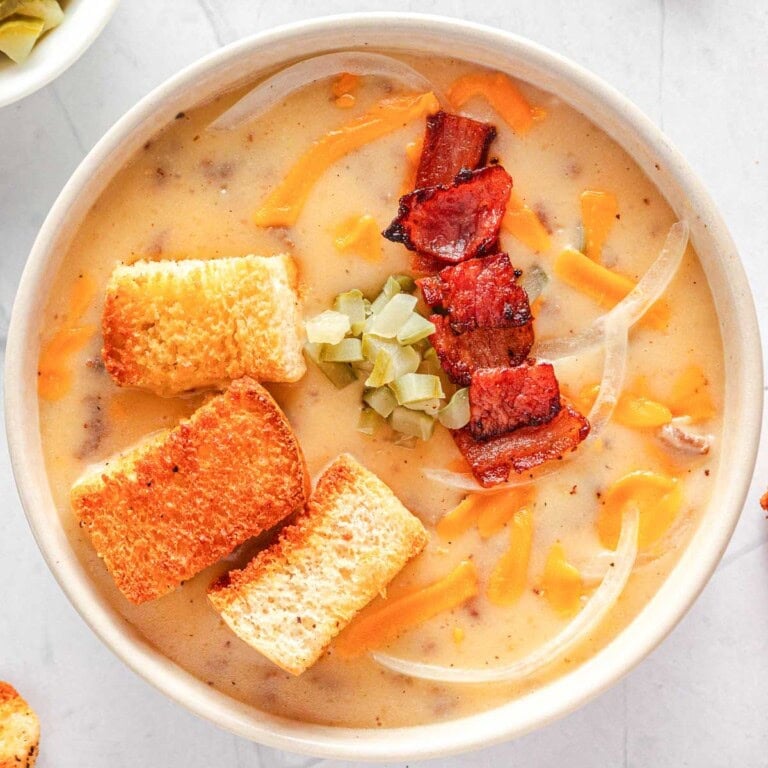 Crockpot Cheeseburger Soup, aerial in bowl with bacon and other garnishes.